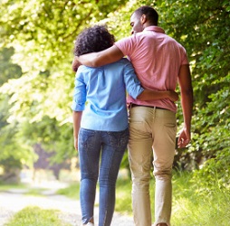 A young couple walk arm-in-arm