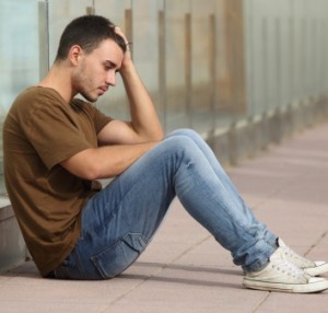 Teen boy worried sitting on the floor