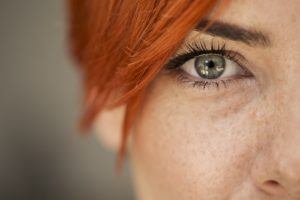Closeup of red haired woman's face, focusing on one eye