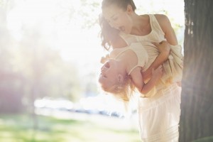 happy mother and baby having fun near tree