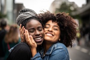 Two women smiling and hugging each other