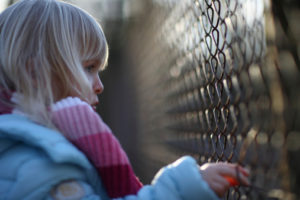 Sad girl by fence 