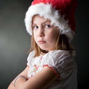 grumpy child with a santa hat