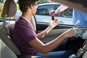Cropped view of teenage driver receiving keys from parent