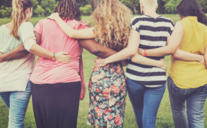Rear view photo of line of moms with arms linked