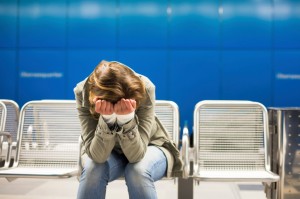 Stressed woman in metro station holds her head in her hands