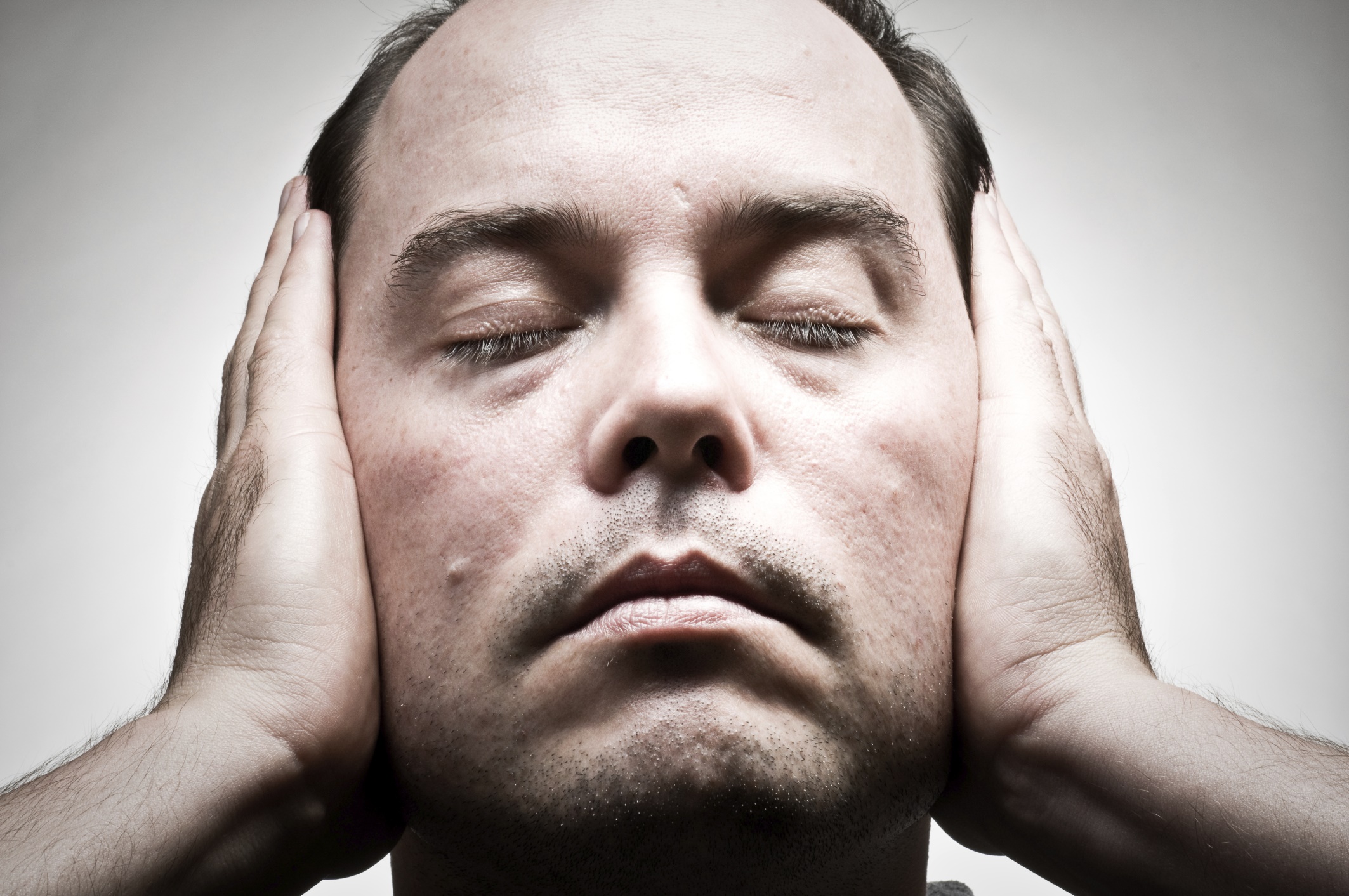 man covering his ears