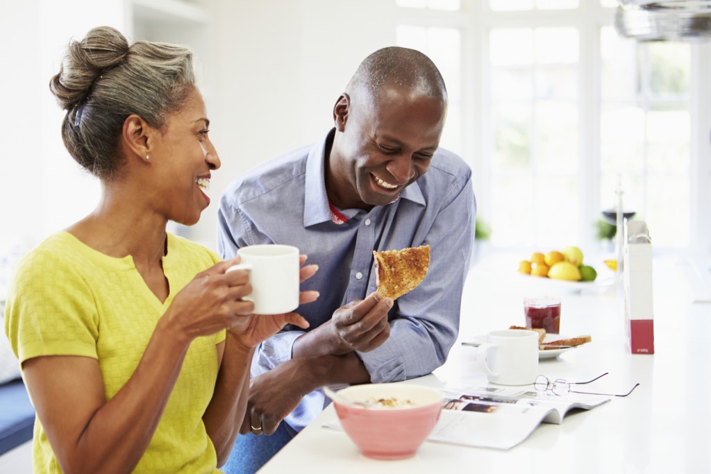 A mature couple laughs over breakfast