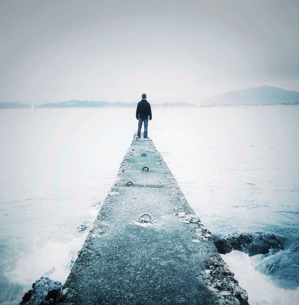 Man standing on sea wall