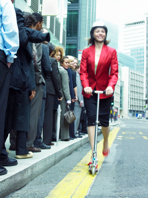 Businesswoman rides scooter past line of people