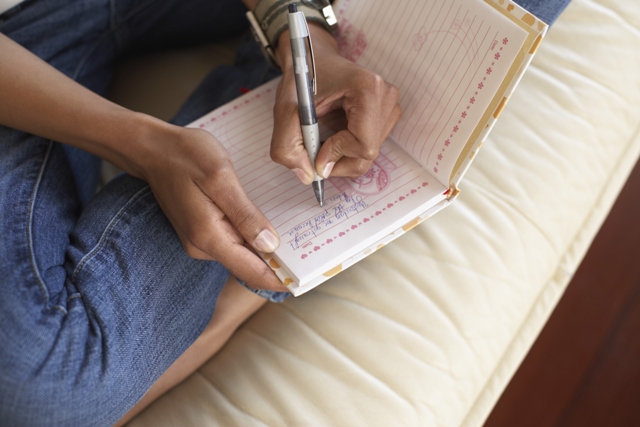 Woman's hands writing in journal