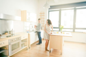 Couple in kitchen washing up after meal