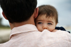 Father carrying baby daughter (15-18 months) outdoors, close-up