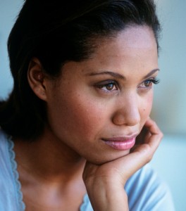 Mid adult woman with hand on chin,looking away,close-up