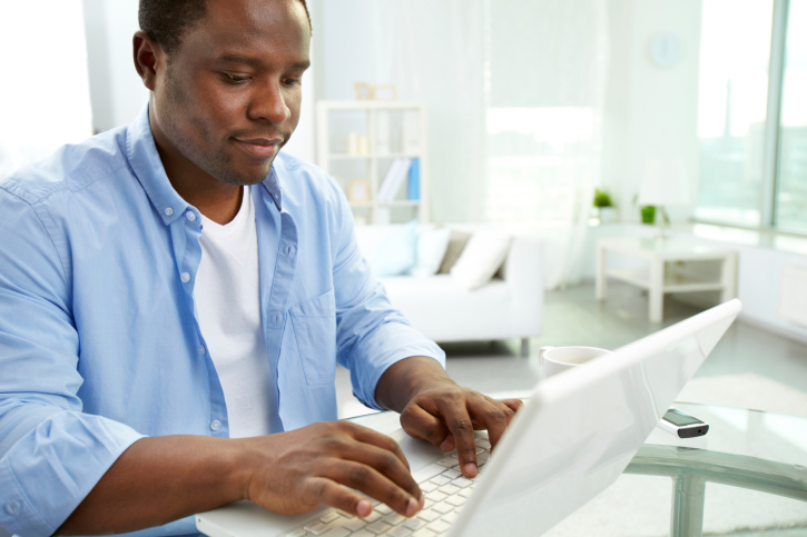 man blogging on laptop
