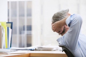 Business man with hands behind head in office