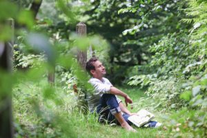 Man relaxing with book in countryside
