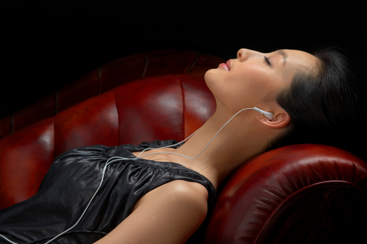 Woman wearing headphones, eyes closed