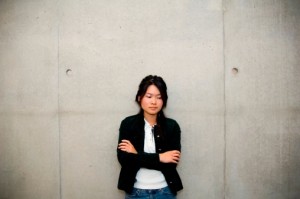 woman standing against cement wall.