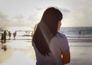 Girl stood looking towards the distant sea