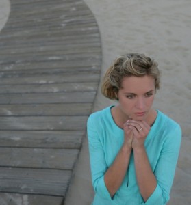 High angle view of young woman standing near wooden walkway.
