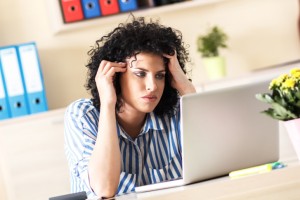 Exhausted Businesswoman looking at laptop