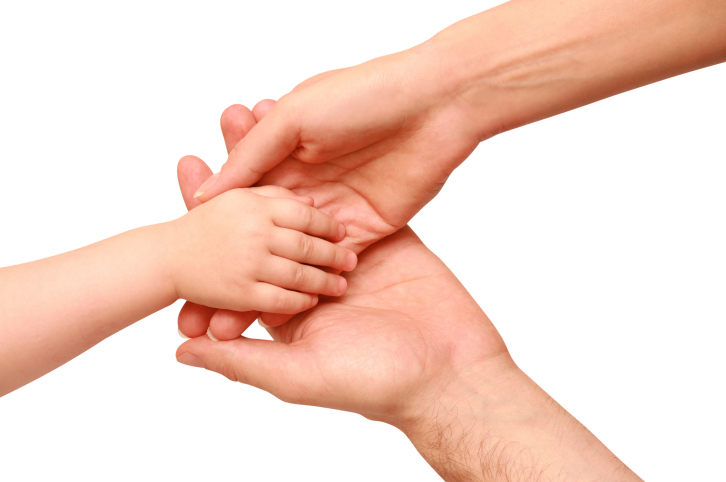 Mother and father holding hands with child