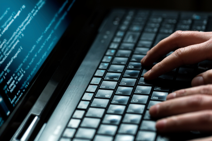 Two hands typing on a keyboard