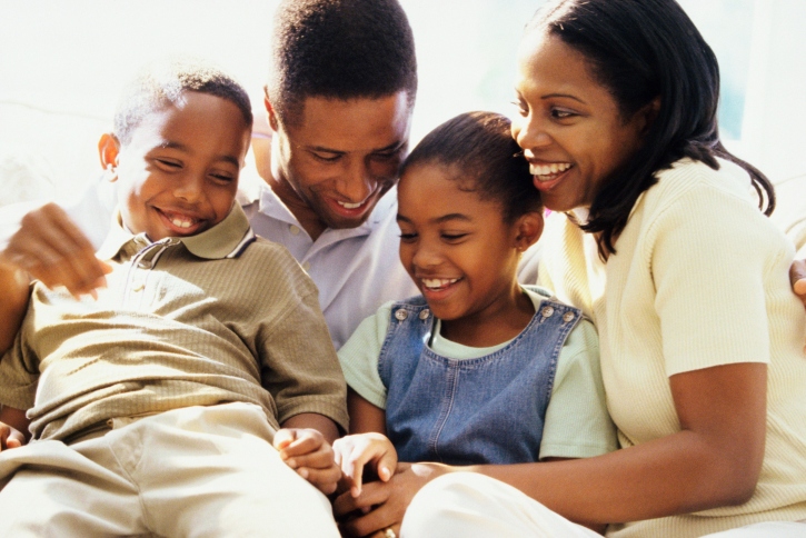 Family of four sitting and laughing together