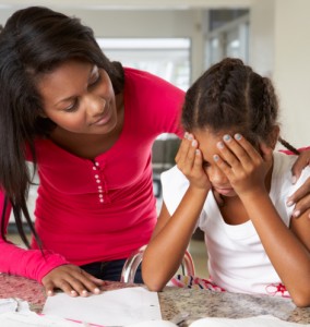 Mother helping child with homework at table