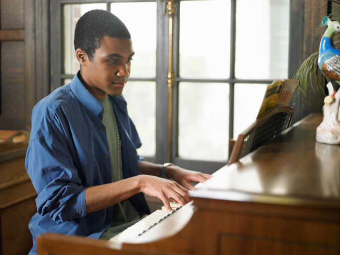 Young man playing piano in house