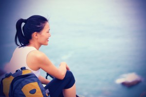 young asian woman hiker sit mountain rock