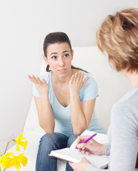A young woman talks in a therapy session