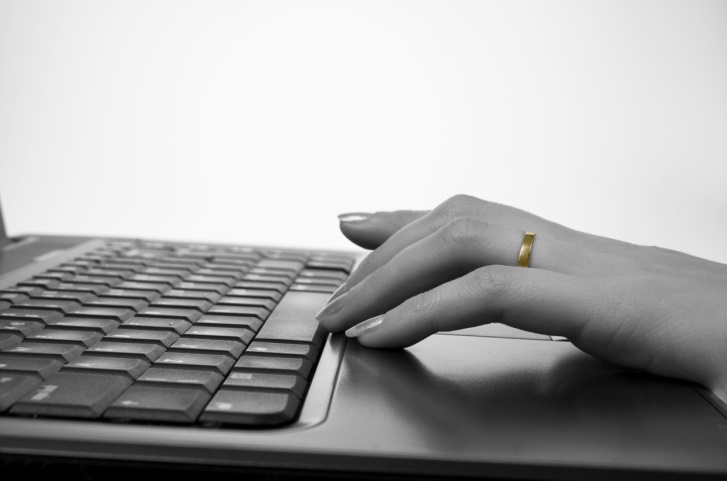 hand with wedding ring on keyboard