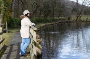 Mature woman standing on bridge looking at view