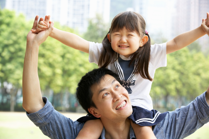 Father giving daughter a ride on his shoulders outside