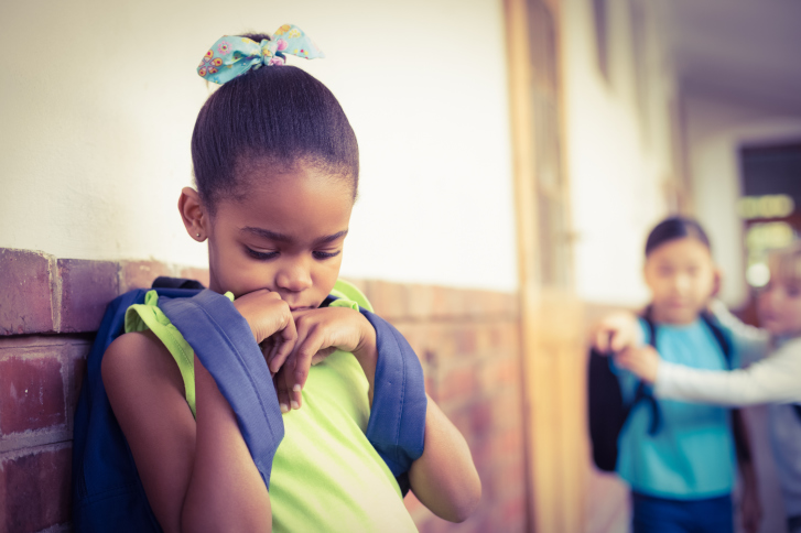 Sad girl being bullied by peers at school