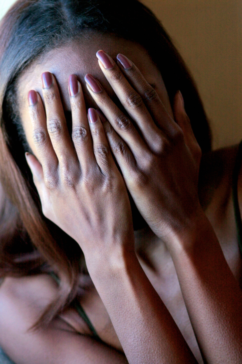 Woman with hands covering face