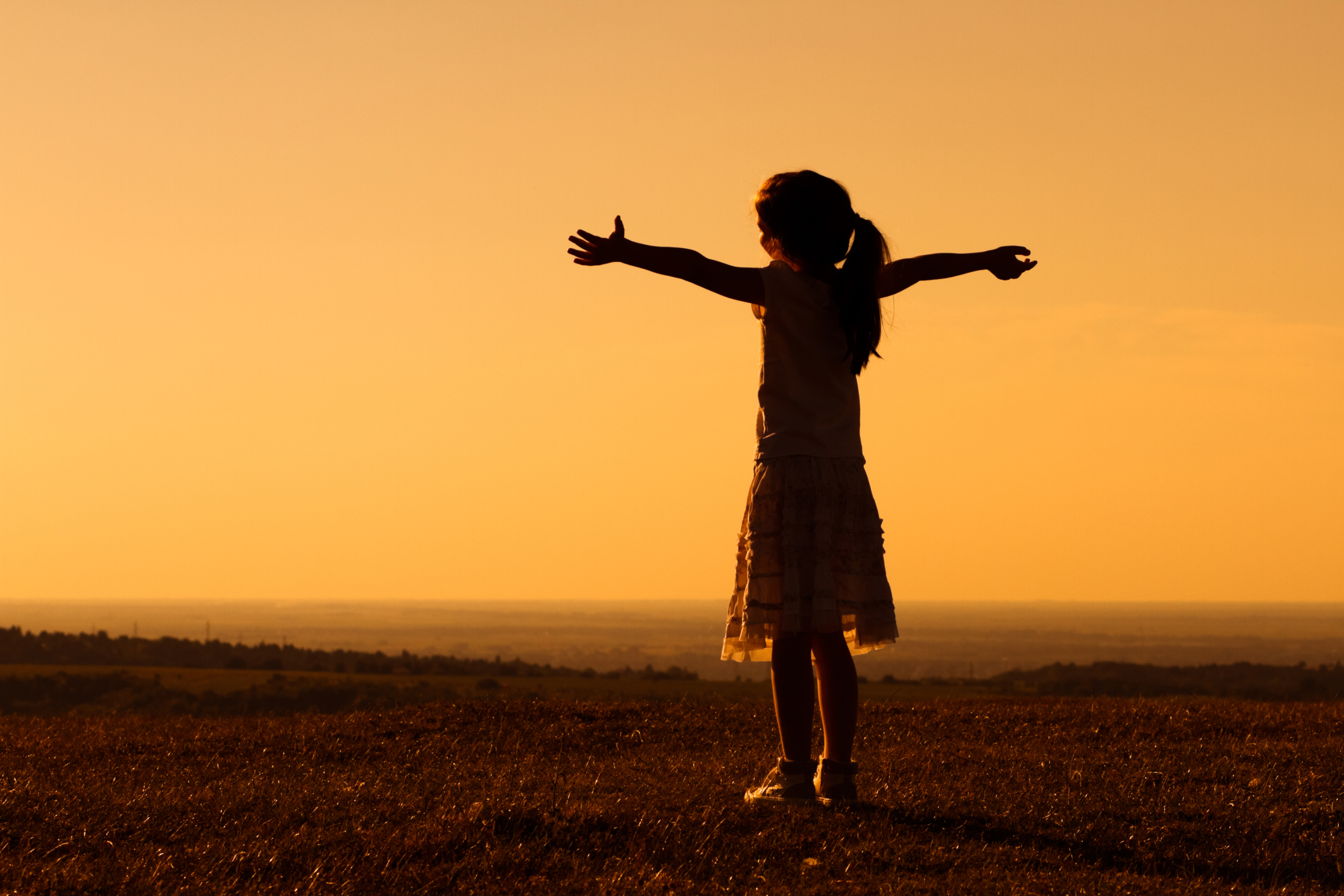 Girl standing outside with her arms outstretched