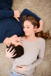 happy young couple together at home lying down on carpet