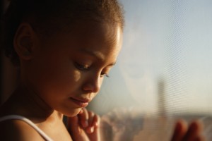 Close up of a little girl looking out a window