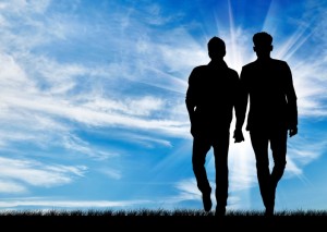 Silhouette of two men walking holding hands