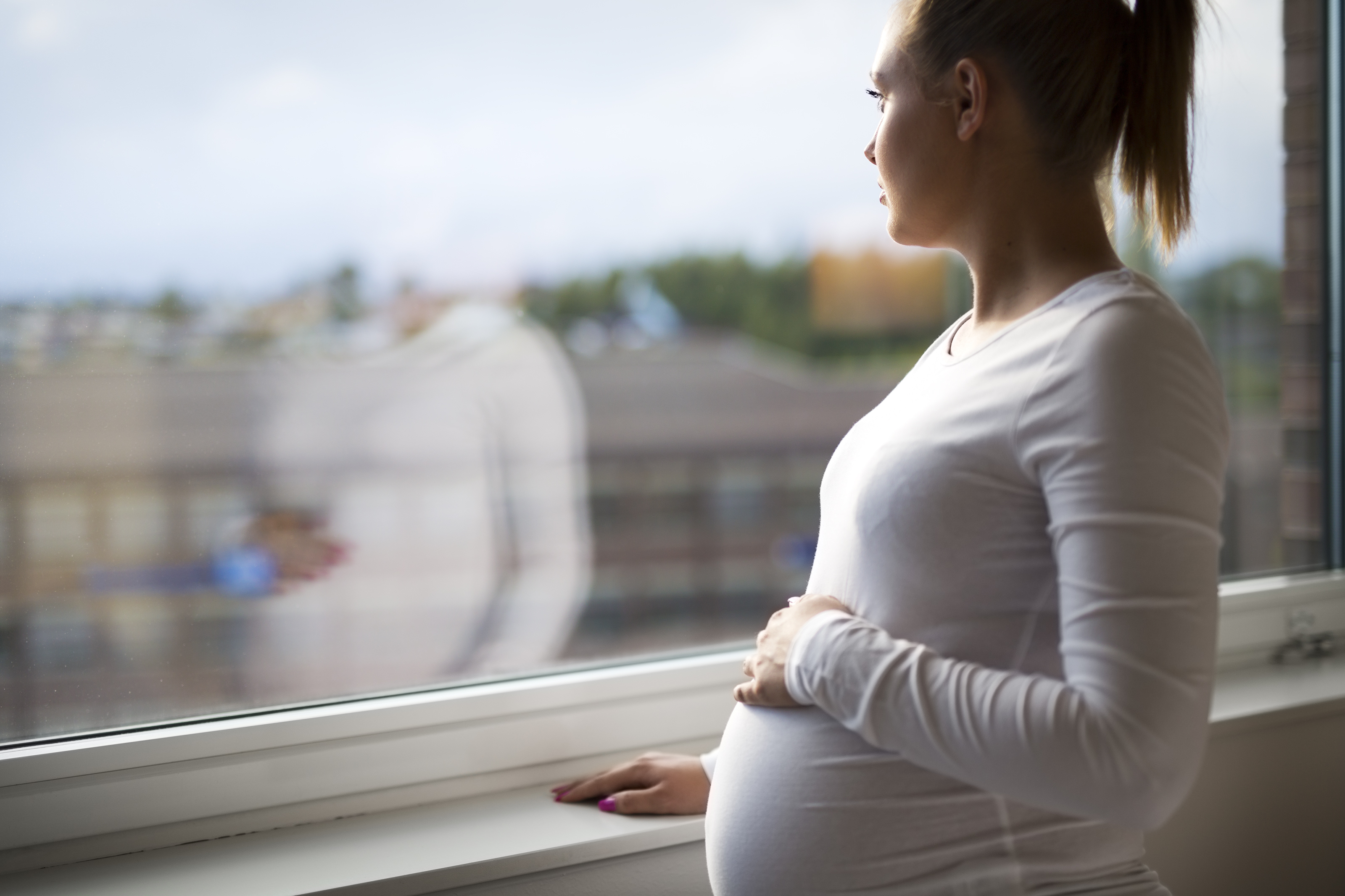 Pregnant woman looking out a window