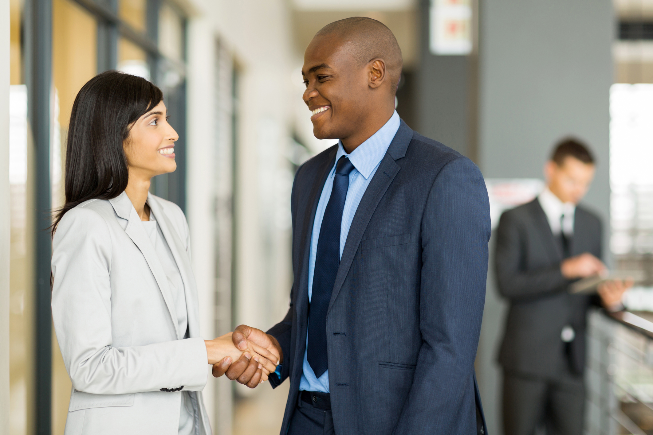 Businesswoman and businessman shaking hands