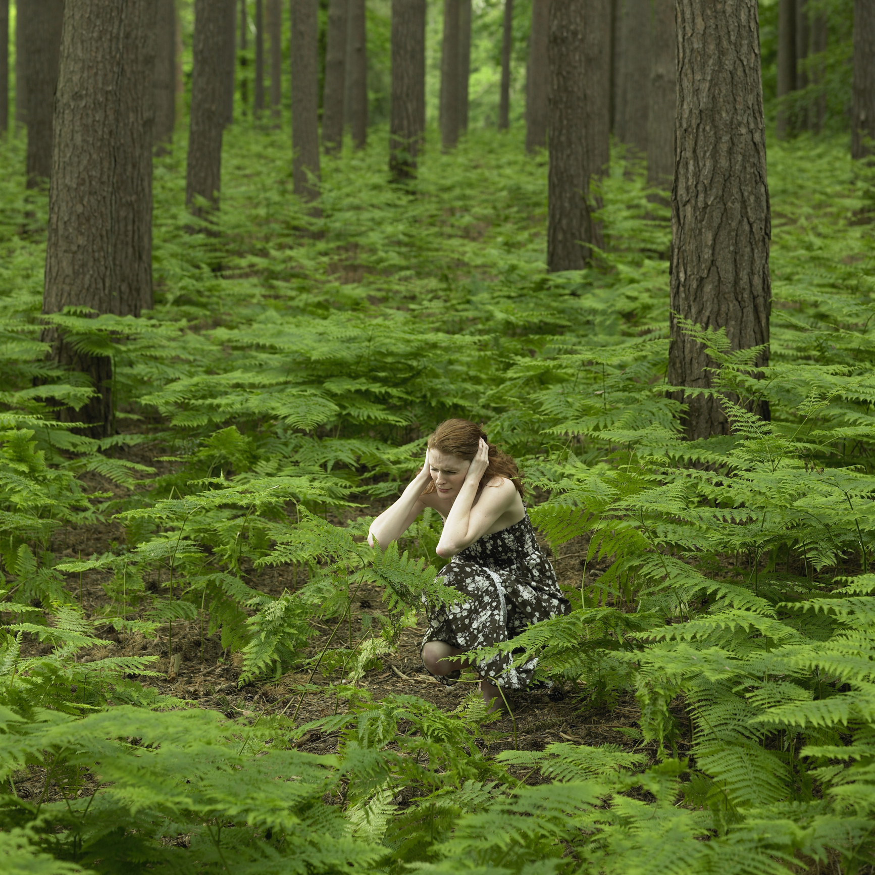 Scared woman hiding in the forest