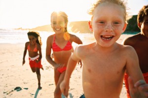 Group of children run along a beach