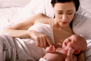 Mother lying in bed with newborn