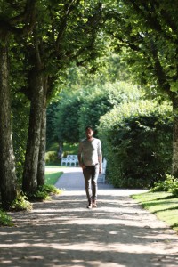 A man walks along a tree-lined path