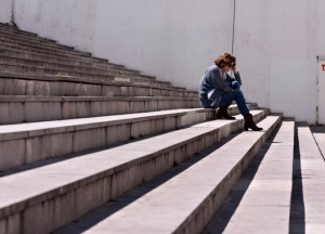 Sitting alone on bleachers with head in hands