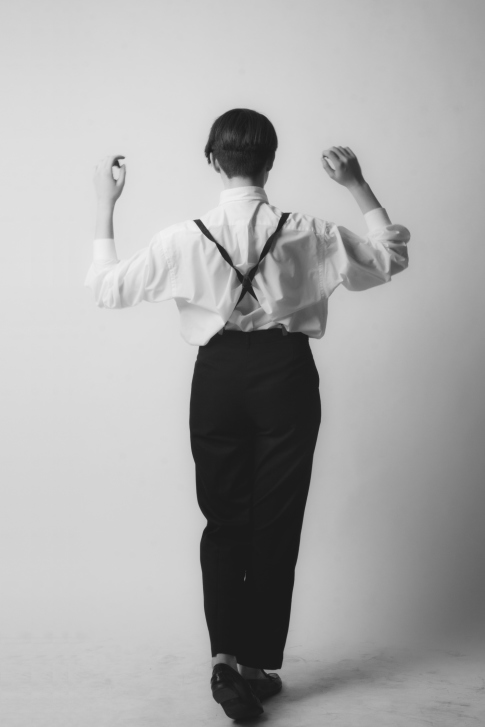 Rear view of a person in suspenders.